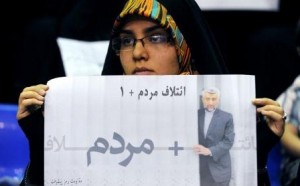 A woman holding a flyer reads "The Coalition of People + 1" which refer to popularity of Iran's top nuclear negotiator. first election campaign in Tehran on May 24,2013. (Photo Credit: Nasim)