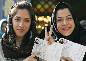 Two Iranian women show their inked fingers and the stamp on their identity cards showing that they have voted. 