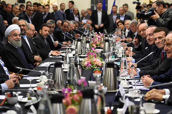 Iranian President Hassan Rouhani (L) attends a meeting with France's Emmanuel Macron (R), Movement of the Enterprises of France (MEDEF) president Pierre Gattaz (2nd-R) and French Foreign Minister Laurent Fabius (3rd-R) in Paris on January 27, 2016. AFP PHOTO
